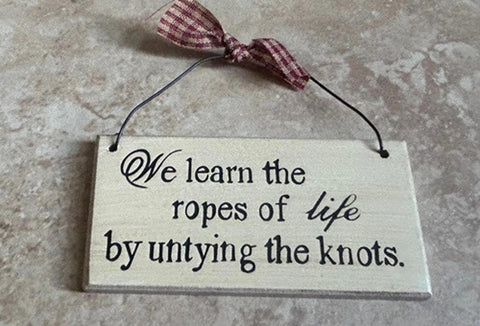 59221K We learn the ropes of life by untying the knots wood sign